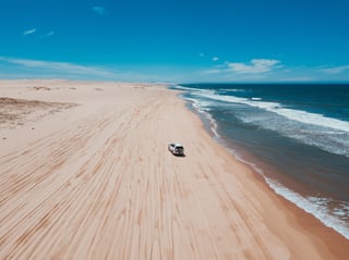 Un 4x4 sur une plage avec des vagues